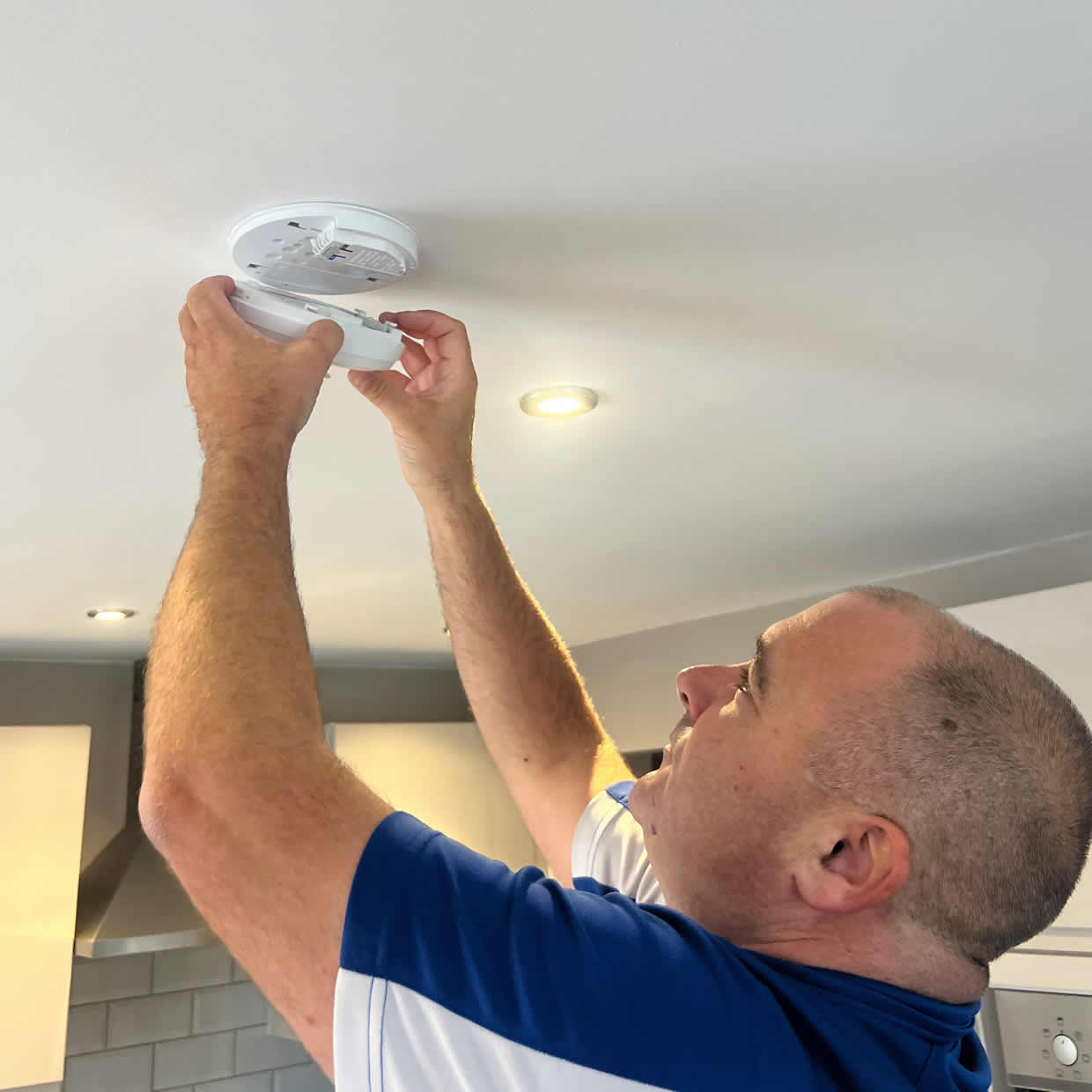 Smoke alarm being installed on a ceiling in Cramlington